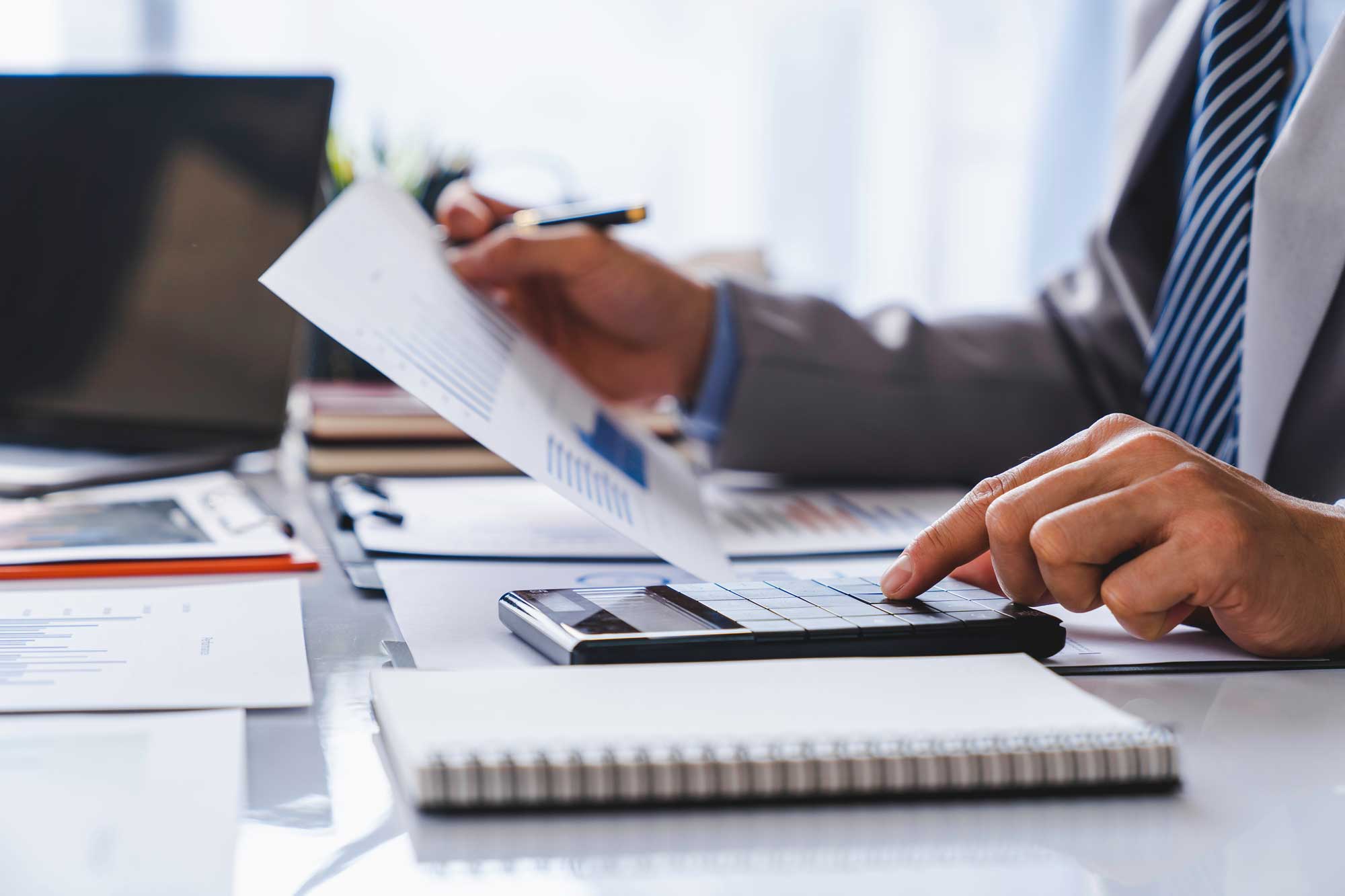 professional_looking_at_document_using_calculator